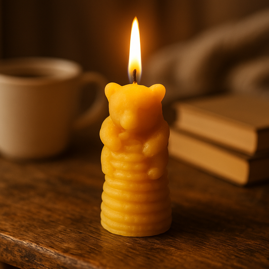 Bear-shaped candle with a lit flame on a wooden surface with a cup and books in the background.