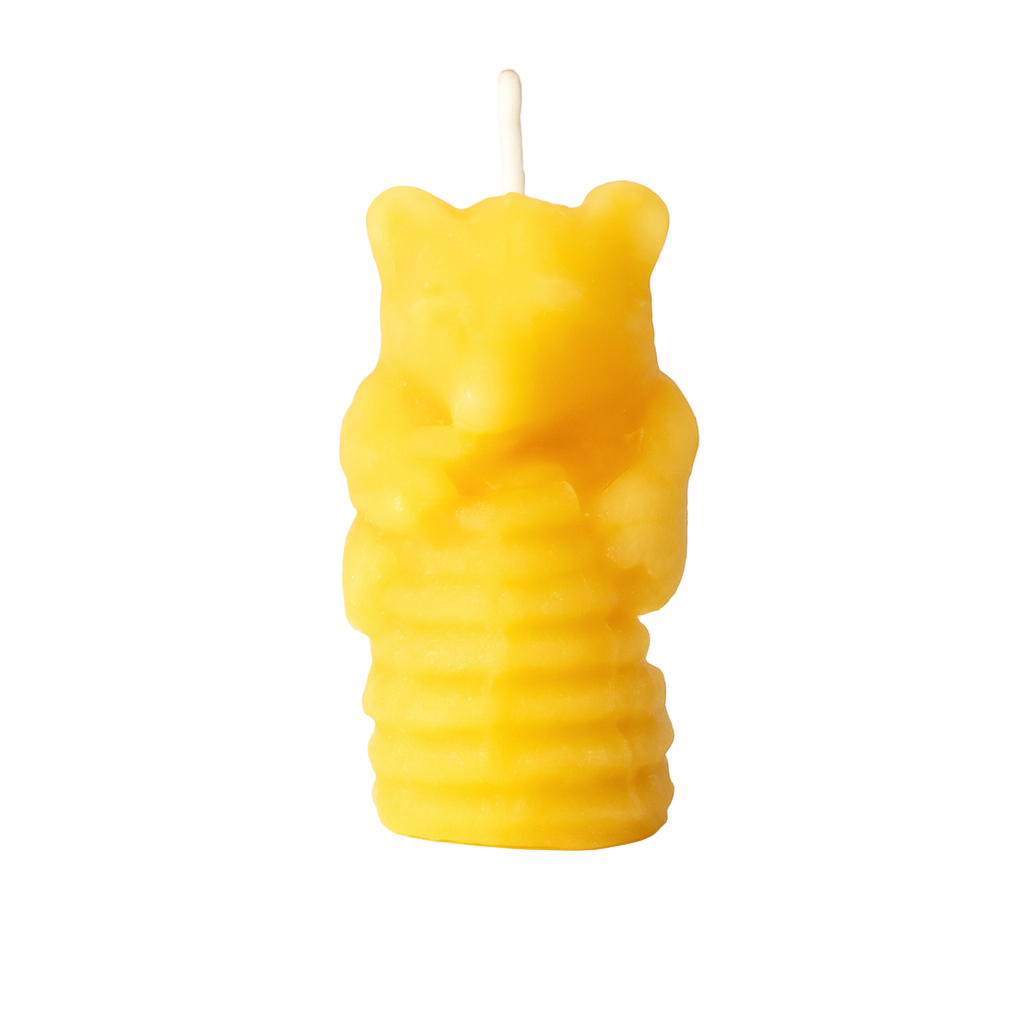 Yellow bear-shaped candle on a white background