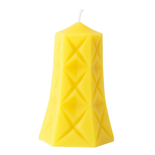 Yellow diamond patterned pillar candle on a white background
