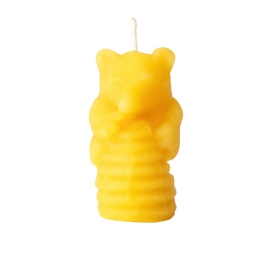 Yellow bear-shaped candle on a white background