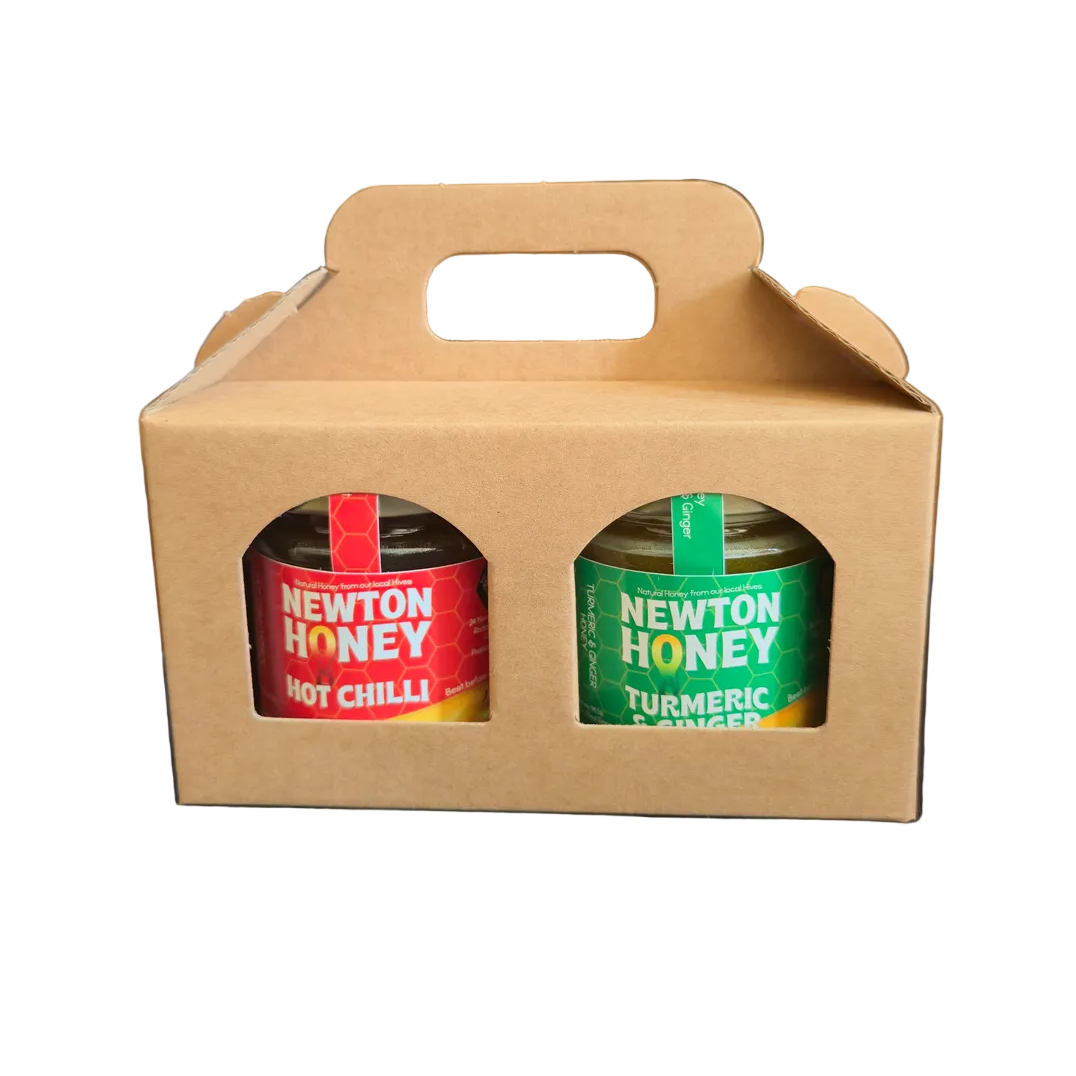 Two jars of Newton Honey in a cardboard kraft carrier on a white background