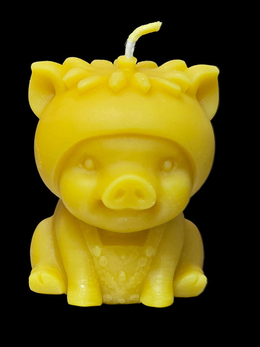 Cute handmade pure beeswax pig candle with flower detail. Natural golden beeswax with a gentle honey scent.
